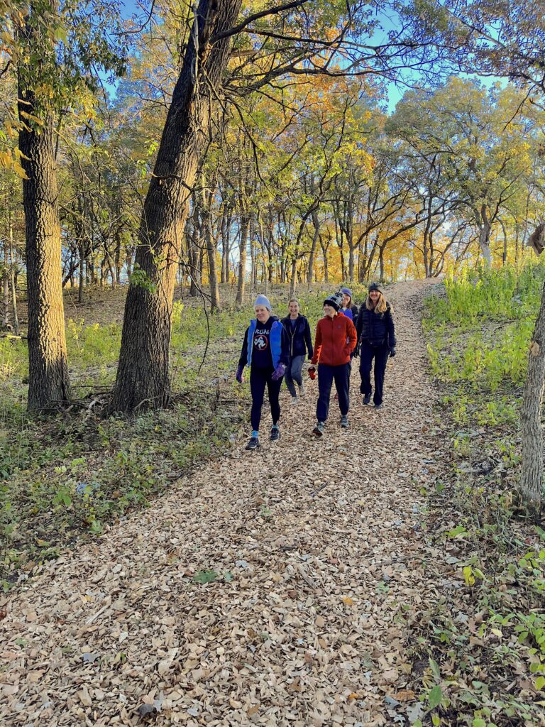 un grupo de personas caminando por un sendero en el bosque.